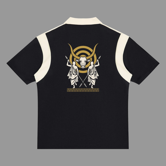 A black short-sleeve polo shirt with cream-colored shoulder panels and collar, featuring a large graphic print on the back with two white classical figures, a gold bull head, and a gold crescent moon.