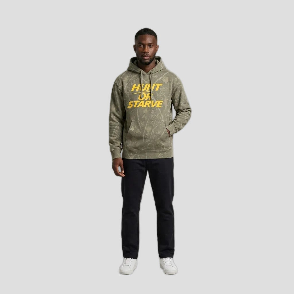 Model wearing the Hunt or Starve Heavyweight Hoodie in Deadwood Camo, PRYNCE studio catalog tile