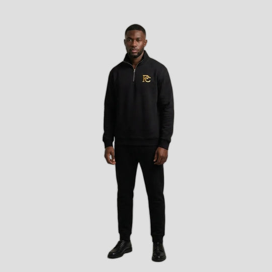 Man wearing the PC Signature Quarter Zip in black with a small gold PC logo on the chest