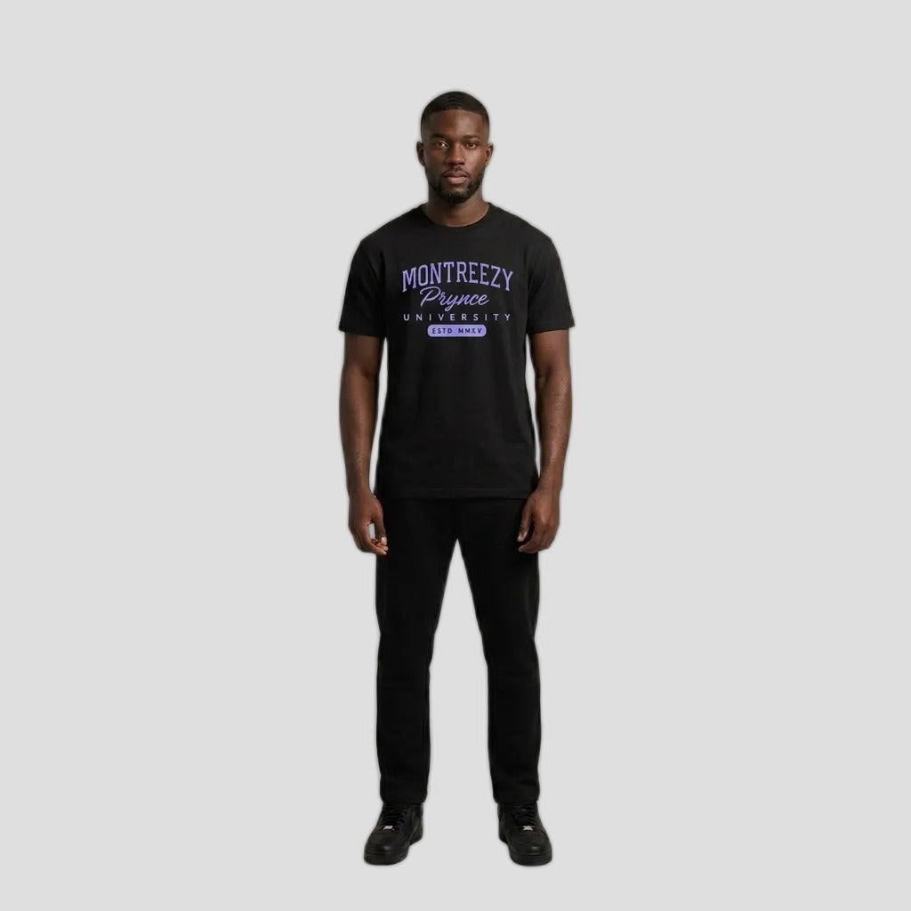 Man wearing the black Montreezy Prynce University Tee with purple collegiate print, full-body studio photo