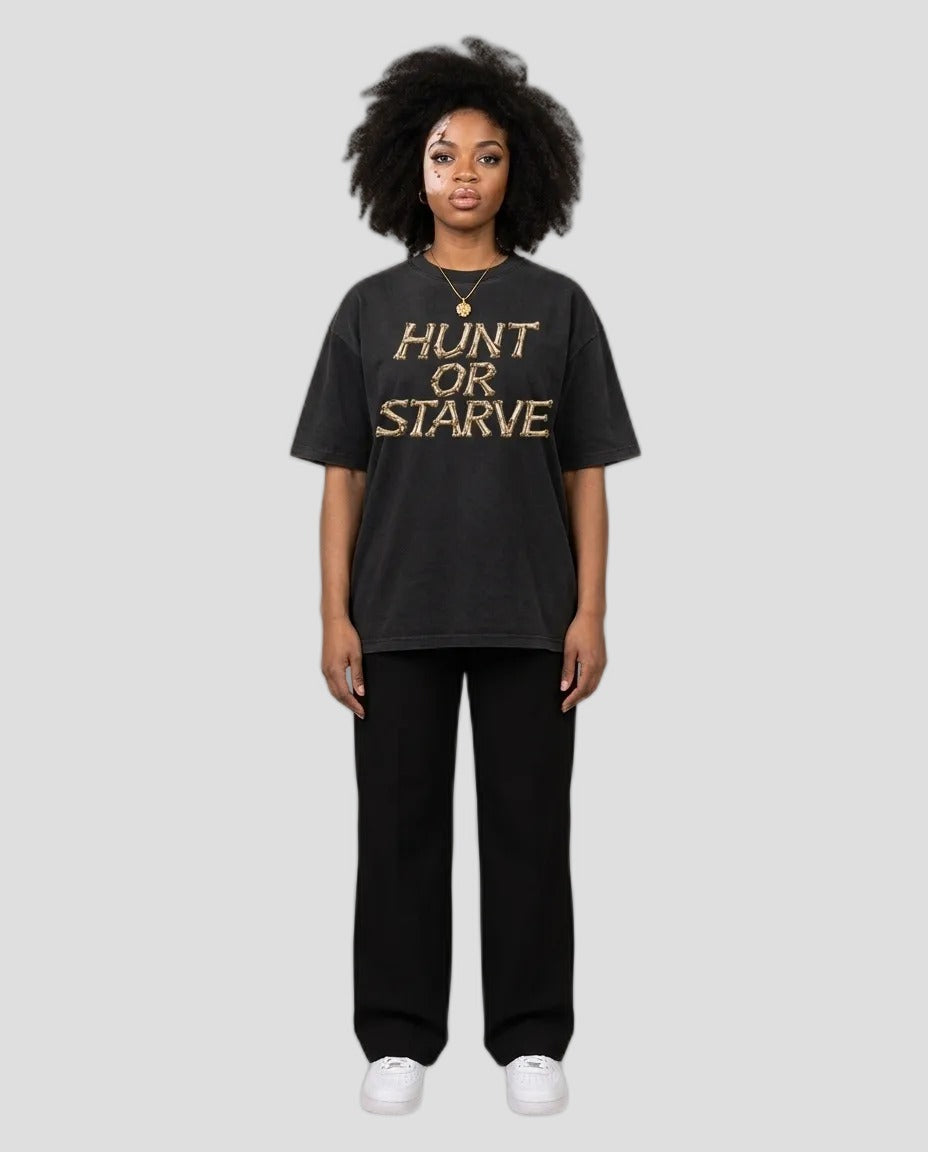 Woman wearing the Washed Hunt or Starve Bone Tee in washed black with tan bone-letter print