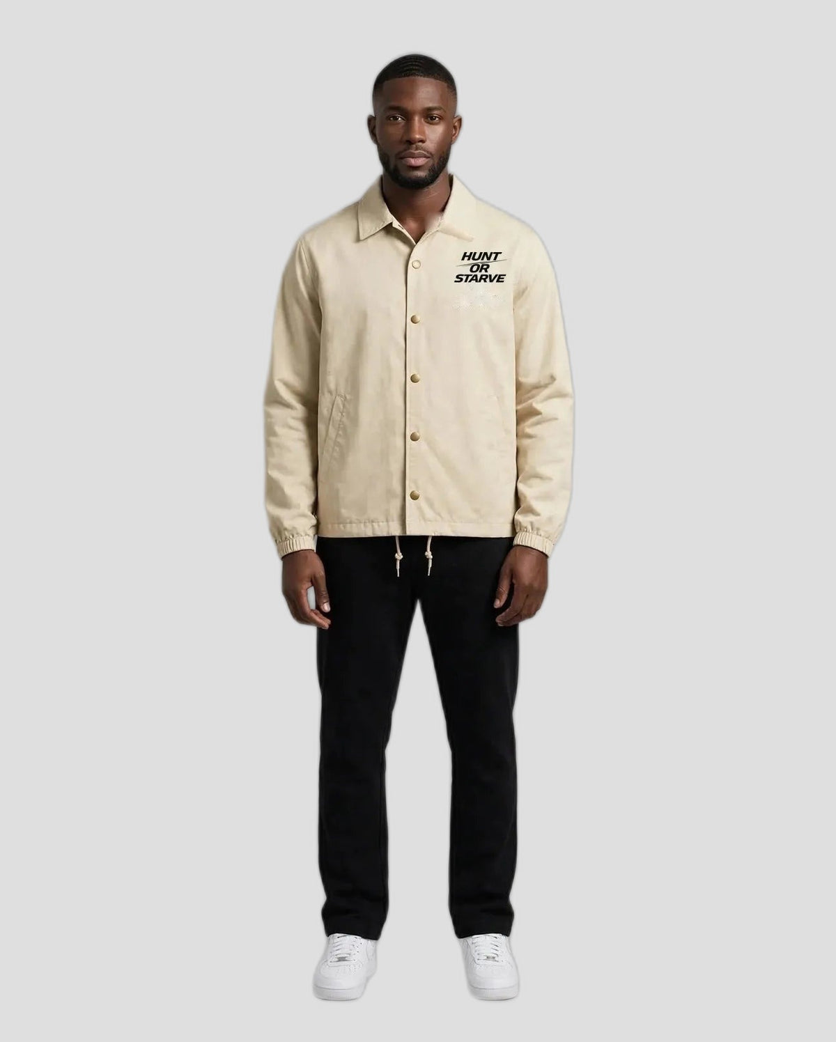 Man wearing the Hunt or Starve Coaches Jacket in beige, front view with small chest logo