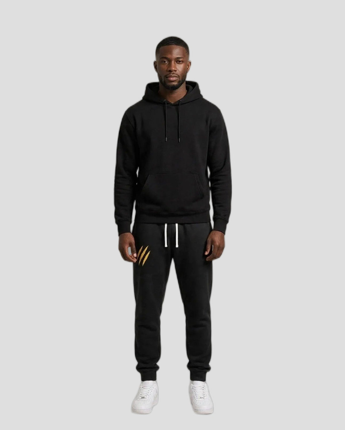 Chris wearing the PRYNCE Claw Marks Sweatpants in black with gold claw marks on the thigh