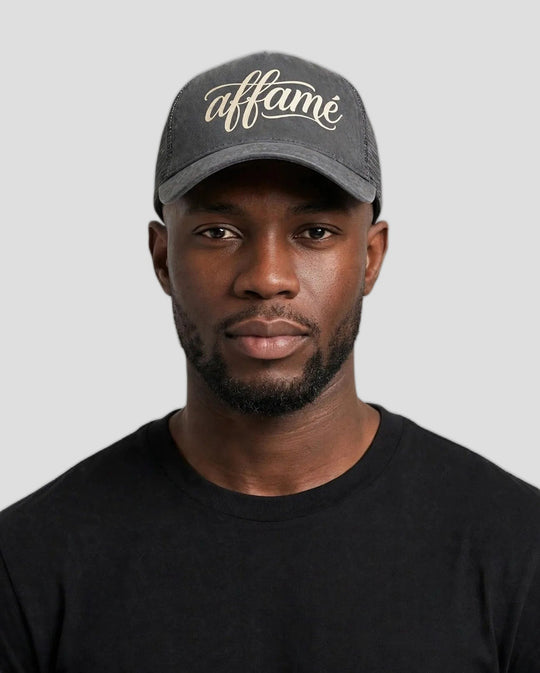 Chris wearing the PRYNCE affamé Mesh Trucker Hat in charcoal with cream script