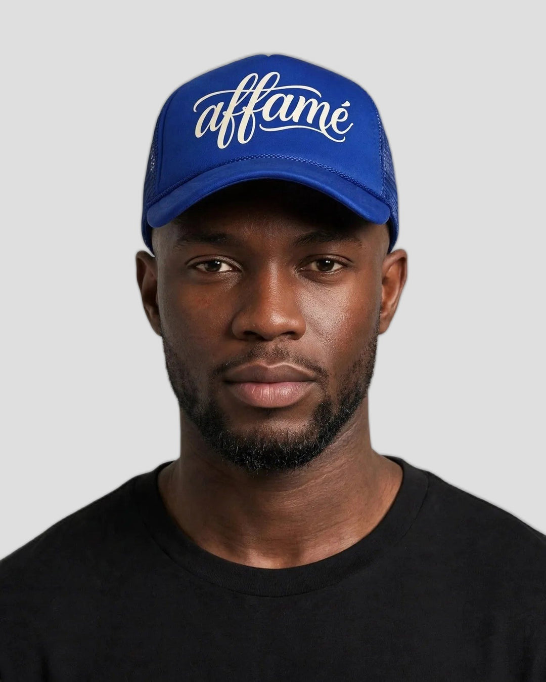 Chris wearing the PRYNCE affamé Royal Mesh Trucker Hat in royal blue with cream script