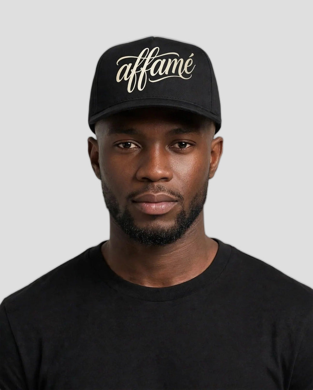 Chris wearing the PRYNCE affamé Black Pro Cap with cream script on a white background