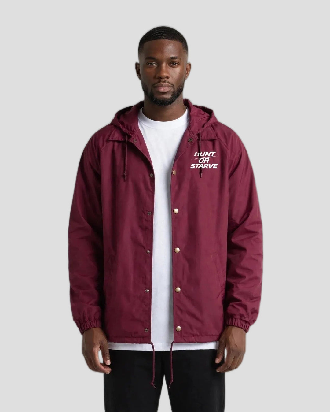 Man wearing the Hunt or Starve Hooded Windbreaker Jacket in burgundy, front view with small chest logo
