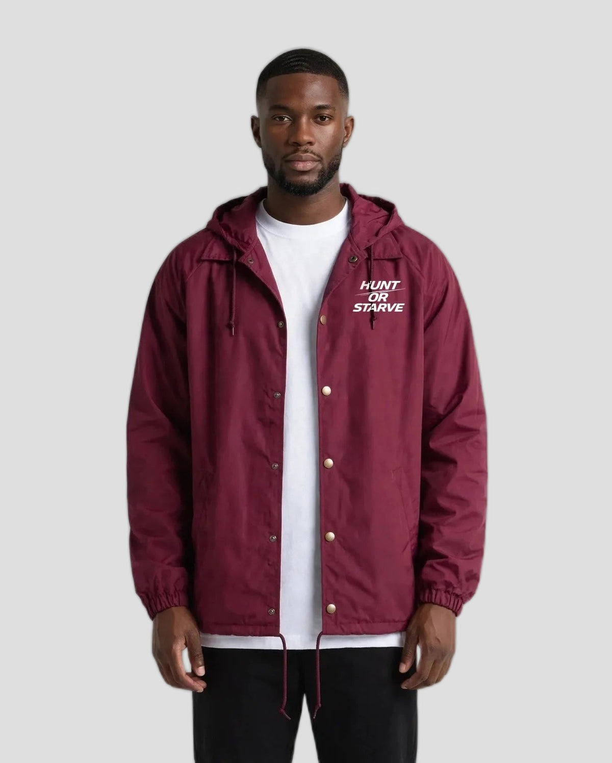Man wearing the Hunt or Starve Hooded Windbreaker Jacket in burgundy, front view with small chest logo