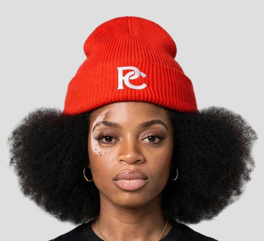 Camila wearing the PC Signature Knit Beanie — red knit beanie with white interlocked PC monogram