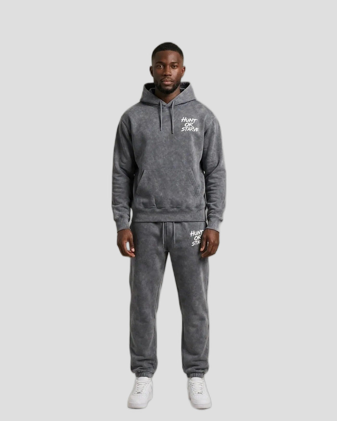 Chris wearing the Endurance H.O.S Mineral Wash Set — grey mineral wash hoodie and sweatpants with Hunt or Starve hits