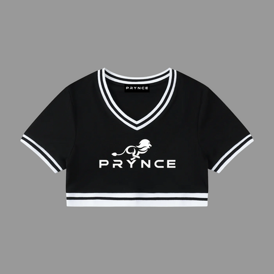 A black short-sleeve cropped V-neck top with white trim and a white printed PRYNCE logo and lion graphic on the front, shown on a plain white background.