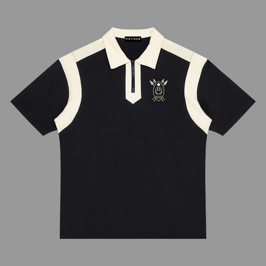 A short-sleeve polo shirt in black with contrasting cream panels on the collar, placket, and shoulders, featuring a circular embroidered logo on the left chest.