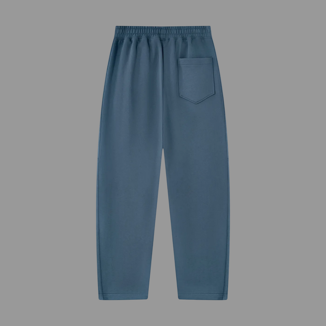 A pair of slate blue lounge pants with an elastic waistband and a single patch pocket on the left side, shown against a plain white background.