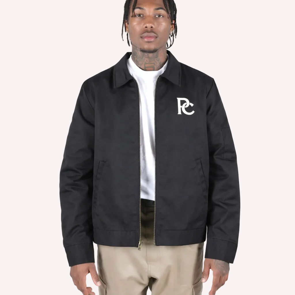 Person wearing a black jacket with a logo on a white background