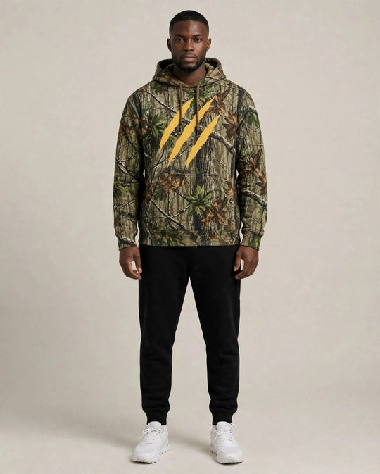 Chris wearing the PRYNCE Claw Marks Forest Camo Hoodie — heavyweight tree camo hoodie with large gold claw marks on the chest