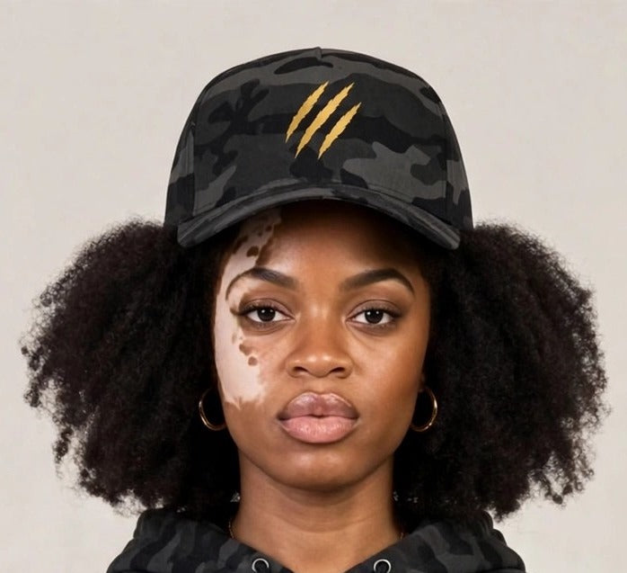 Camila wearing the PRYNCE Claw Marks Black Camo Snapback Hat with gold claw marks, with the matching black camo claw hoodie and sweatpants