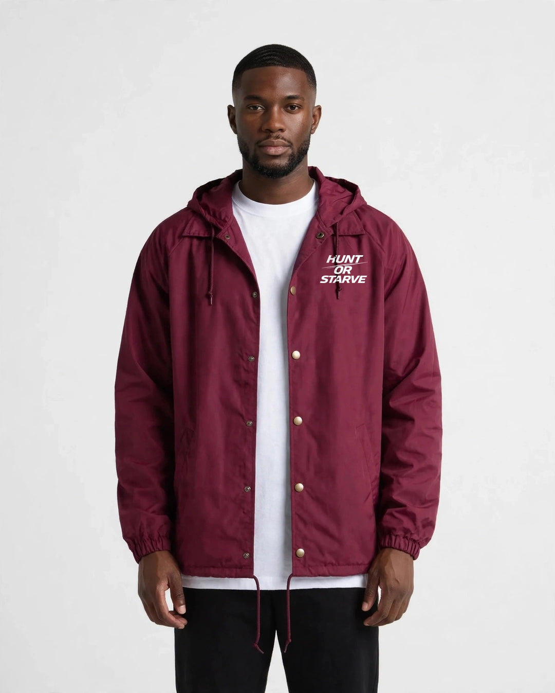 Man wearing the Hunt or Starve Hooded Windbreaker Jacket in burgundy, front view with small chest logo