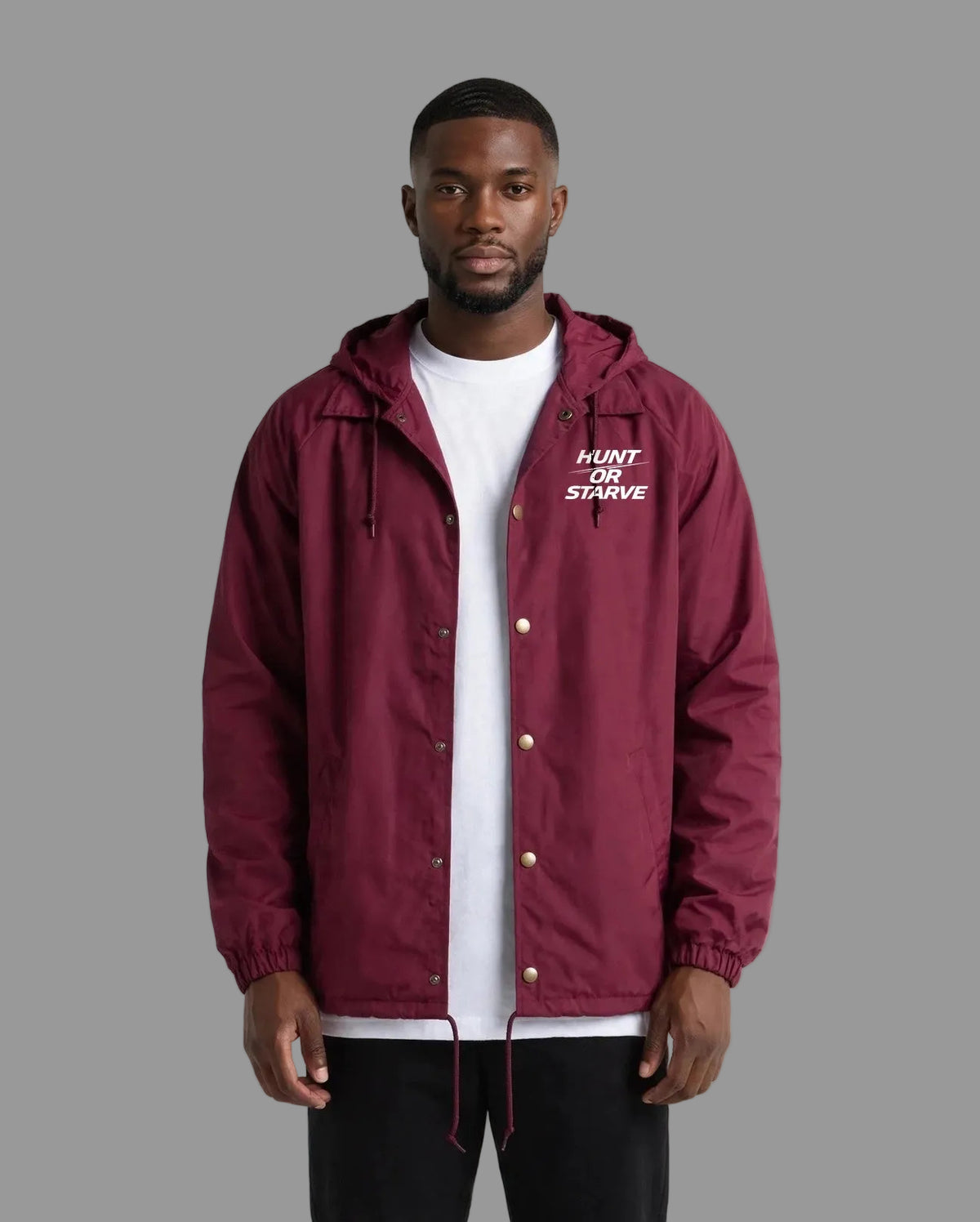 Man wearing the Hunt or Starve Hooded Windbreaker Jacket in burgundy, front view with small chest logo