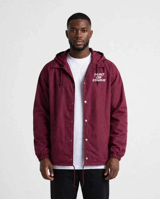 Man wearing the Hunt or Starve Hooded Windbreaker Jacket in burgundy, front view with small chest logo