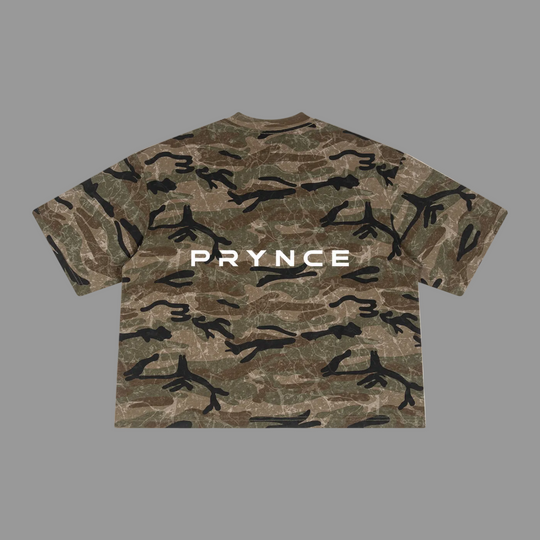 A short-sleeve crewneck t-shirt featuring a brown and green camouflage pattern with black branch-like shapes and the word &