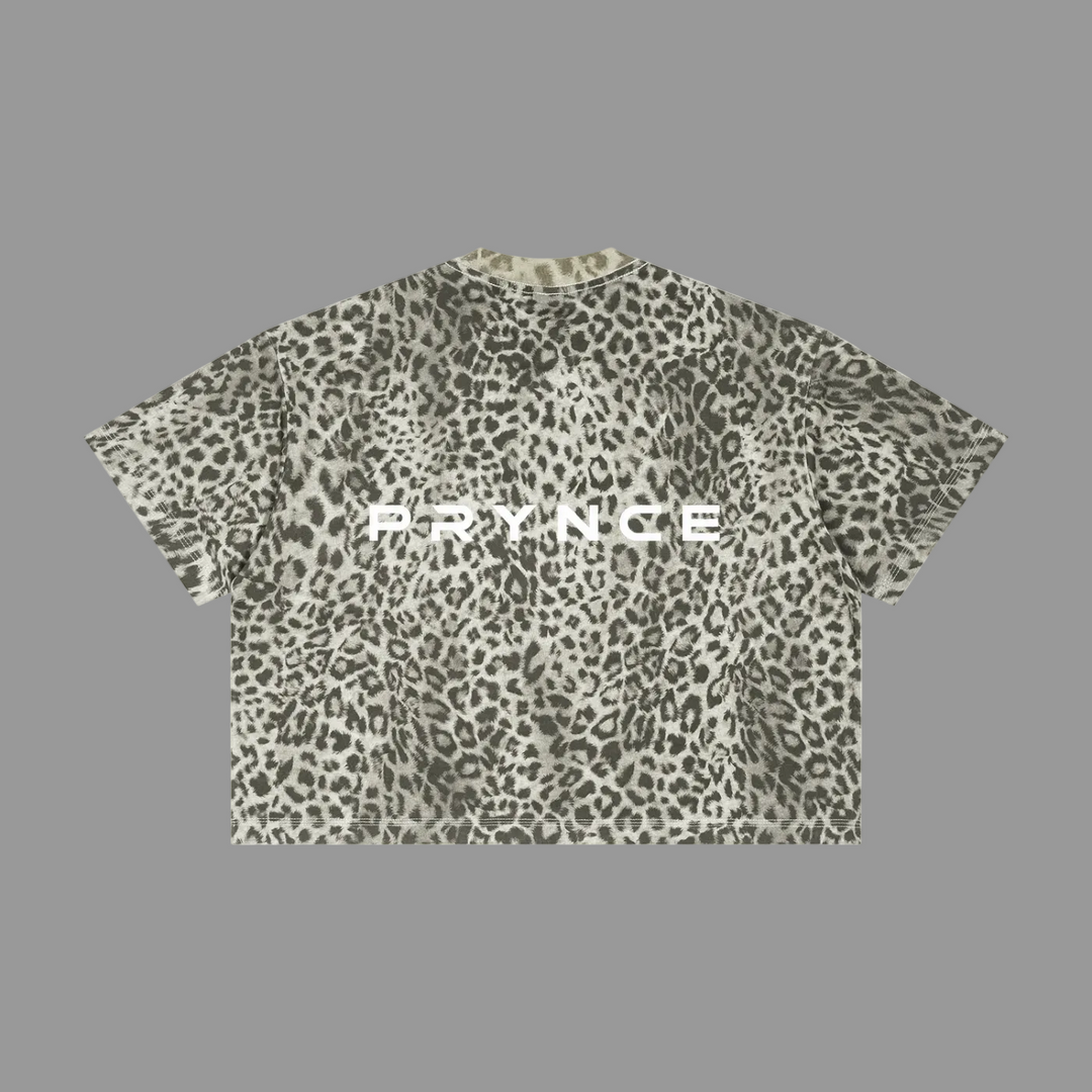 A short-sleeve crop top t-shirt featuring an all-over leopard print pattern in olive green, gray, and black, with the word &
