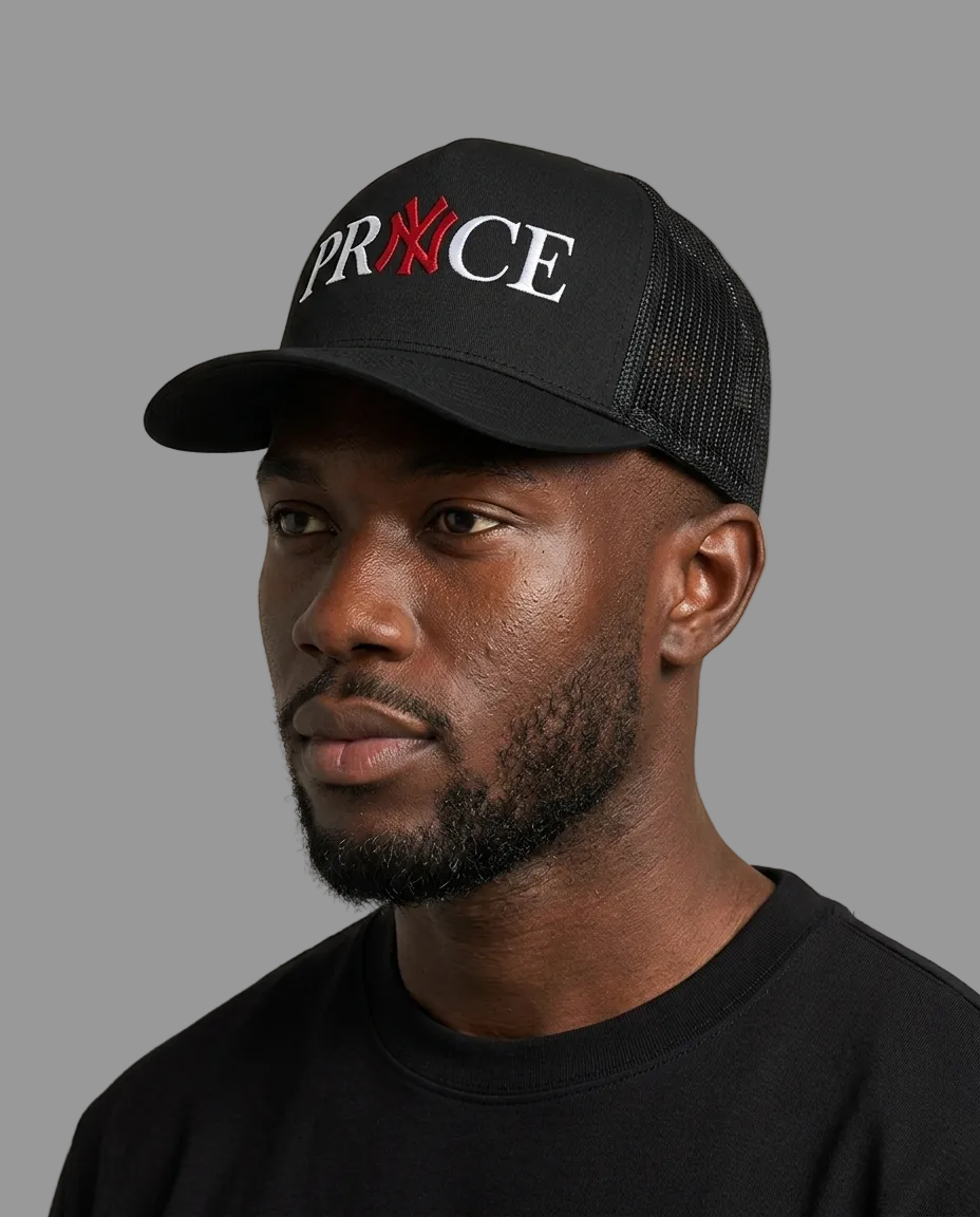A man wearing a black trucker cap with 'PRXCE' embroidered on the front, featuring a red 'X' and white 'PR' and 'CE' lettering, against a plain light gray background.