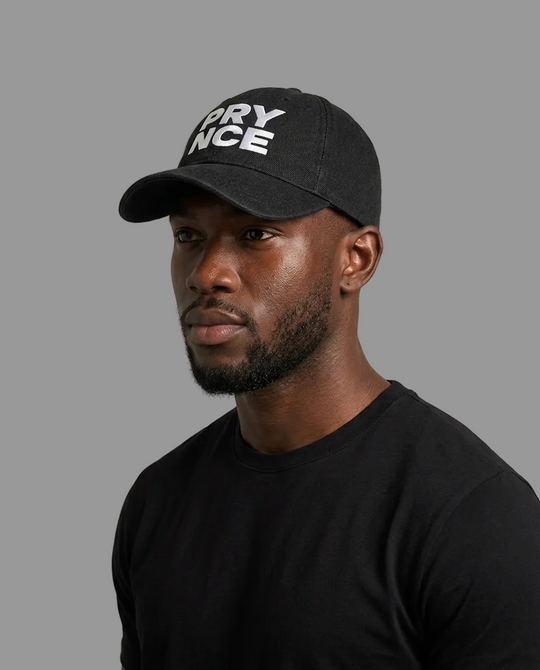 A man wearing a black baseball cap with white embroidered text reading &