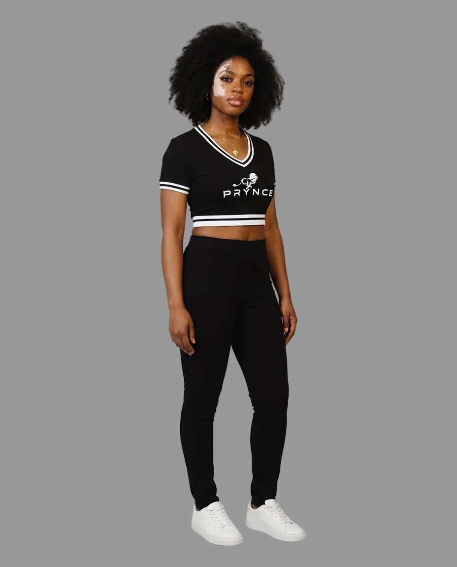 A woman modeling a black short-sleeve crop top with white trim and a white &