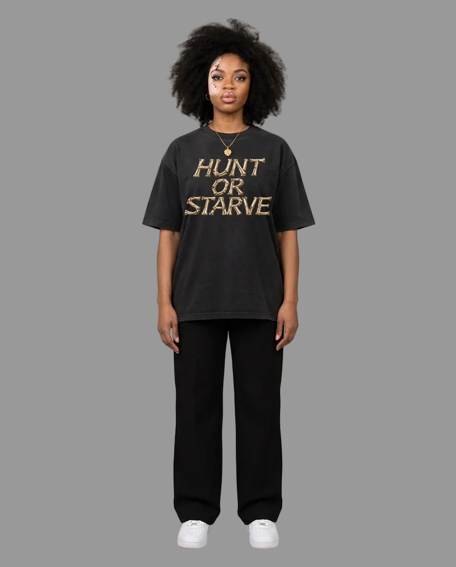 A model stands against a neutral beige studio background wearing a black graphic t-shirt with the words &