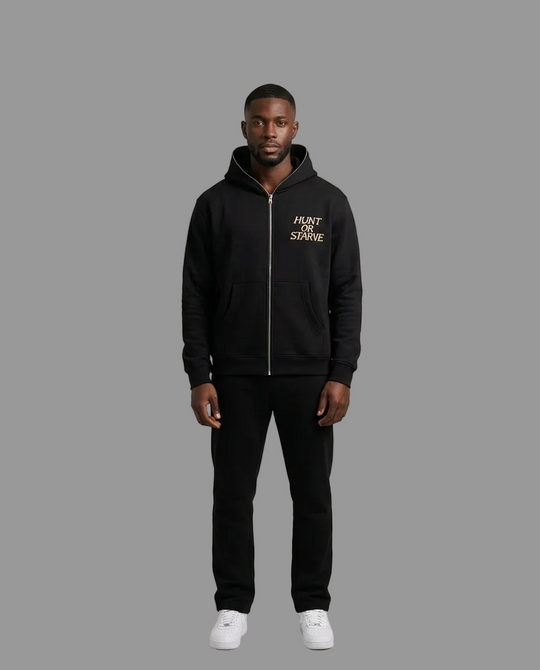 A man modeling a black zip-up hoodie with a gold &