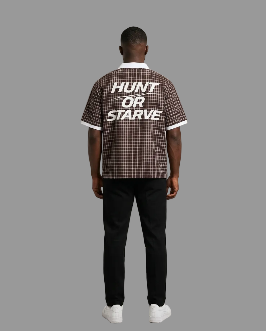A man viewed from behind wearing a brown and black checkered short-sleeve shirt with &