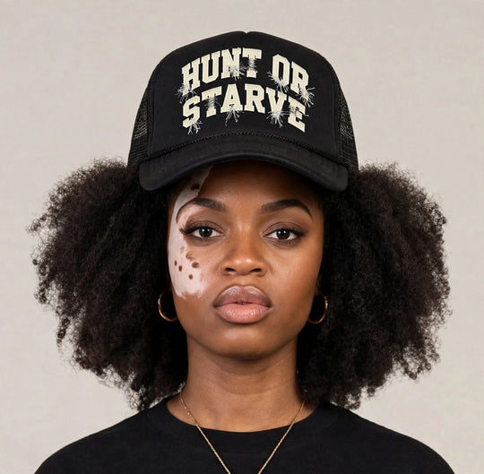 Camila wearing the Hunt or Starve Varsity Foam Trucker Hat — black foam trucker hat with cream varsity HUNT OR STARVE arch print