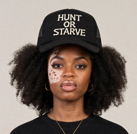 Camila wearing the Hunt or Starve Bones Foam Trucker Hat — black foam trucker hat with HUNT OR STARVE bone letters print