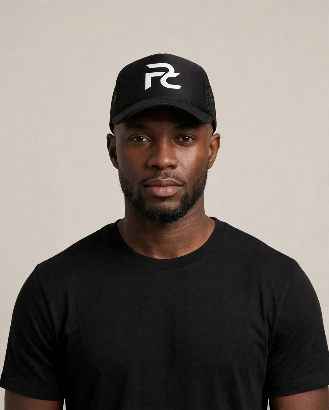 Chris wearing the PRYNCE PC Monogram Foam Trucker Hat — black foam trucker hat with white interlocked PC monogram print