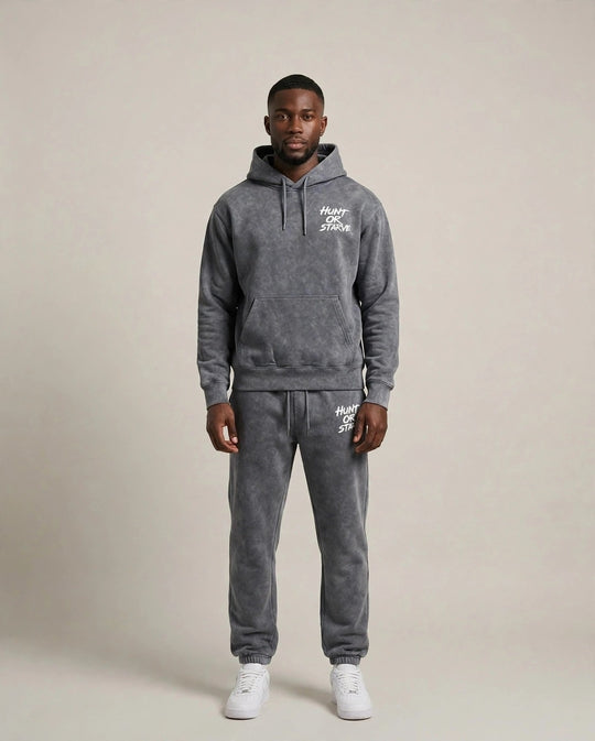 Chris wearing the Endurance H.O.S Mineral Wash Set — grey mineral wash hoodie and sweatpants with Hunt or Starve hits