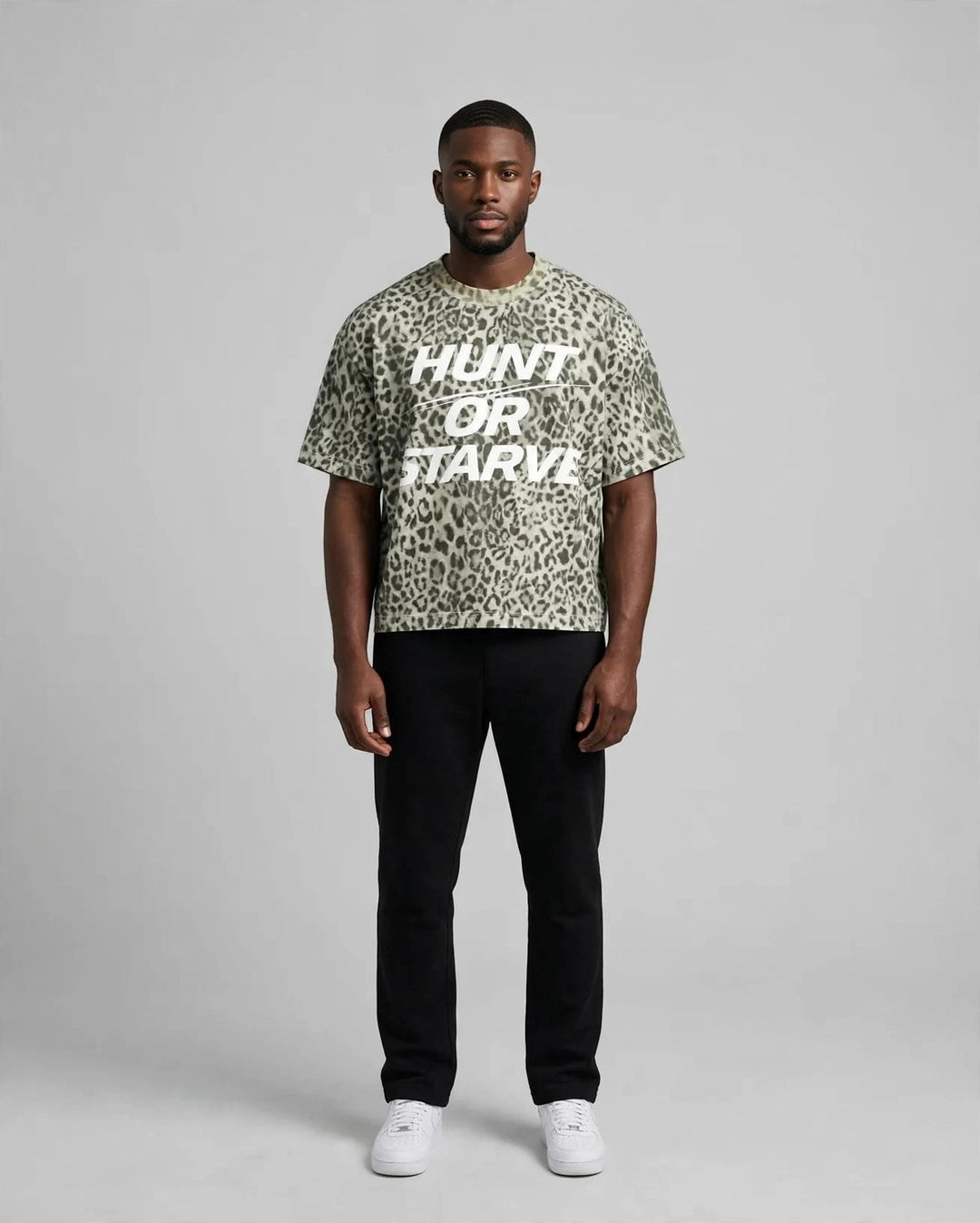 Chris wearing the PRYNCE Predator Boxy Tee — leopard print boxy t-shirt with white HUNT OR STARVE print