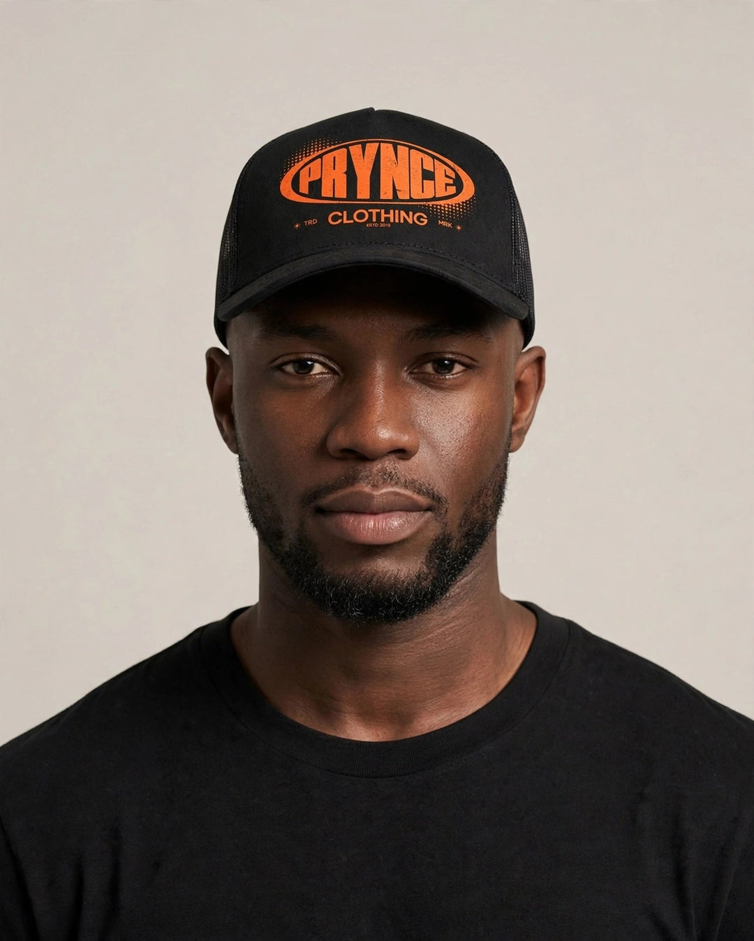 Chris wearing the PRYNCE Republic Oval Foam Trucker Hat — black foam trucker with orange PRYNCE oval print
