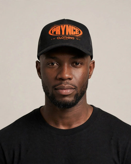 Chris wearing the PRYNCE Republic Oval Foam Trucker Hat — black foam trucker with orange PRYNCE oval print