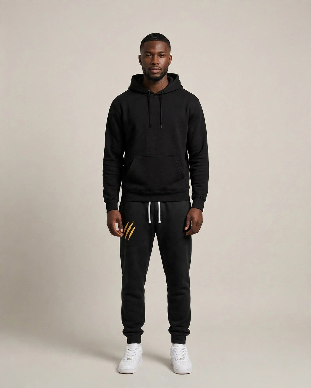 Chris wearing the PRYNCE Claw Marks Sweatpants in black with gold claw marks on the thigh