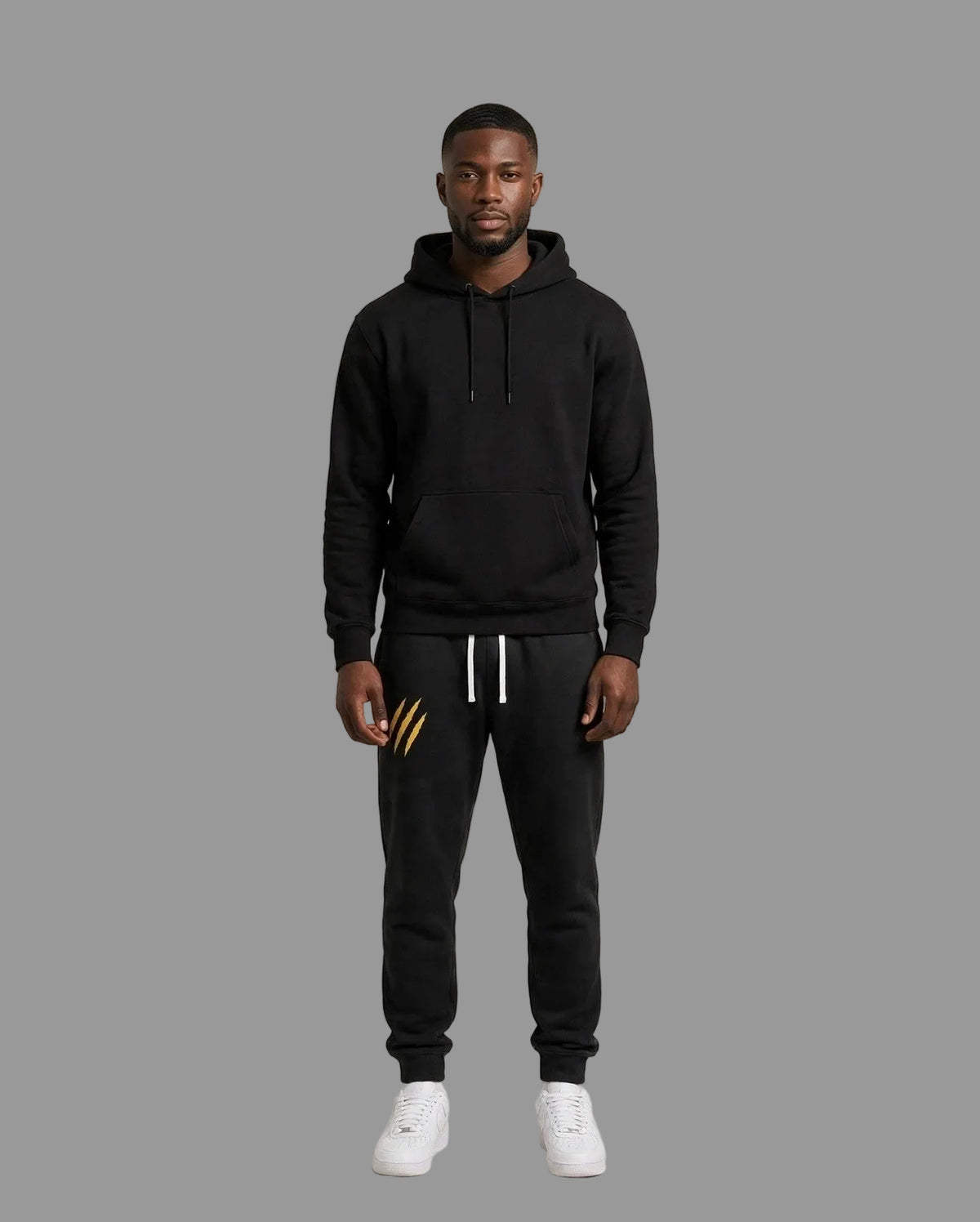 Chris wearing the PRYNCE Claw Marks Sweatpants in black with gold claw marks on the thigh