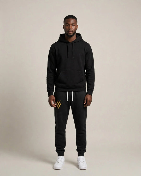 Chris wearing the PRYNCE Claw Marks Sweatpants in black with gold claw marks on the thigh